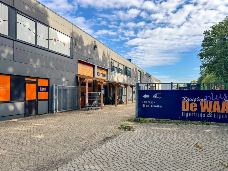 Route naar de goederenontvangst van Kringloopwinkel De WAAR in Emmen, aangegeven met het bord Brengen bij de 2e roldeur.